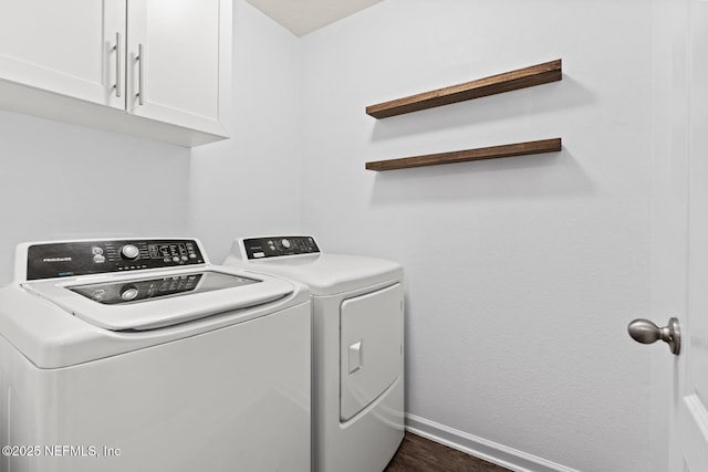 laundry area featuring baseboards, cabinet space, dark wood-type flooring, and independent washer and dryer