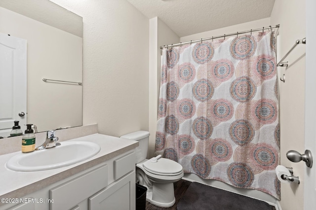 bathroom with a textured ceiling, toilet, vanity, and a shower with curtain