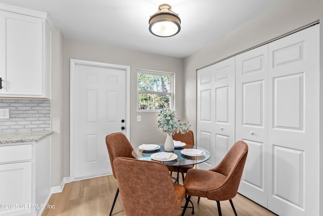 dining area featuring baseboards and light wood-style floors