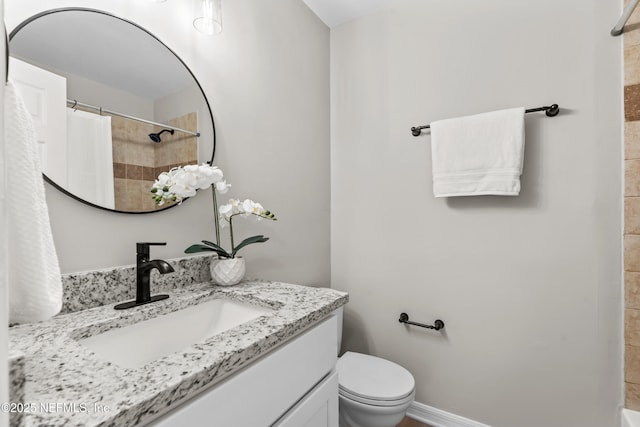 bathroom with toilet, baseboards, vanity, and a shower with curtain