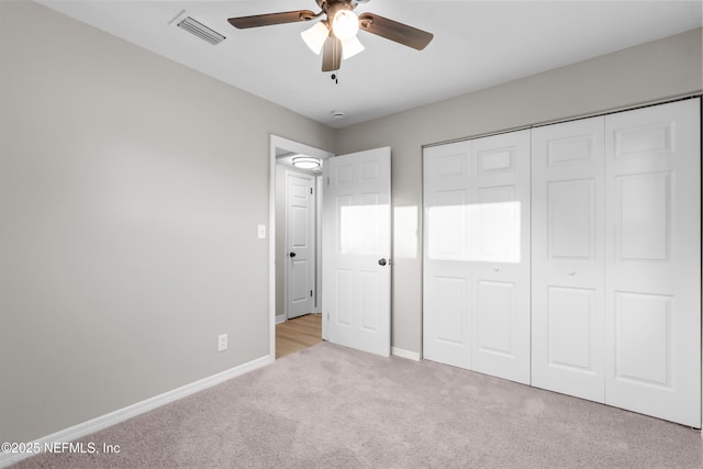 unfurnished bedroom featuring ceiling fan, visible vents, baseboards, a closet, and carpet