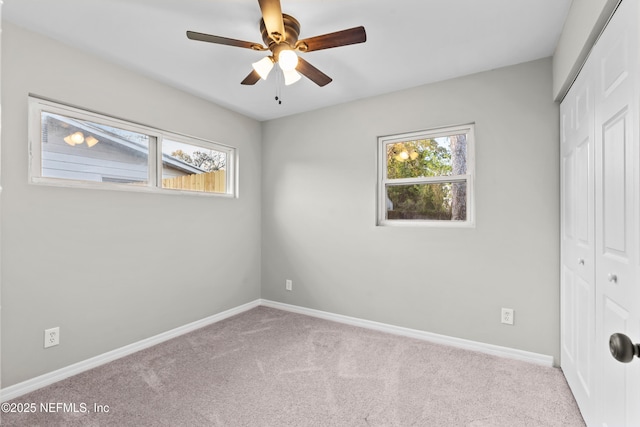 unfurnished bedroom with carpet floors, a closet, a ceiling fan, and baseboards