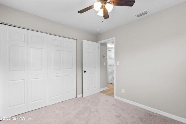 unfurnished bedroom featuring carpet floors, a ceiling fan, visible vents, baseboards, and a closet