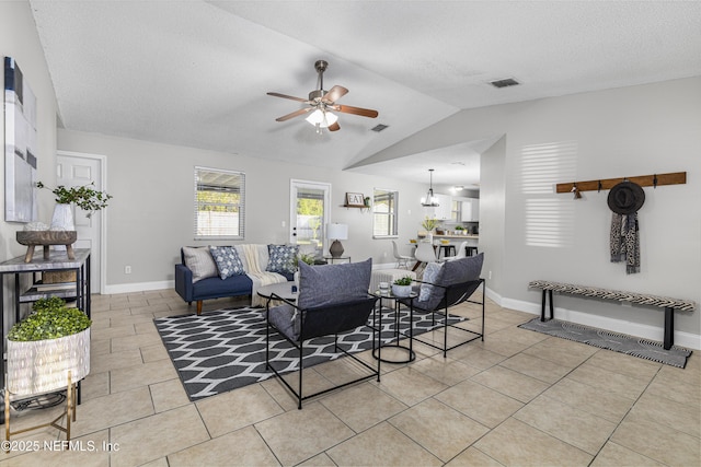 living room with light tile patterned floors, visible vents, lofted ceiling, and a ceiling fan