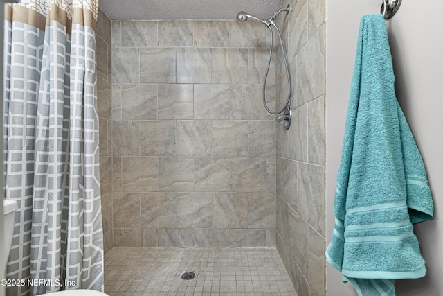 full bathroom with a shower stall and a textured ceiling