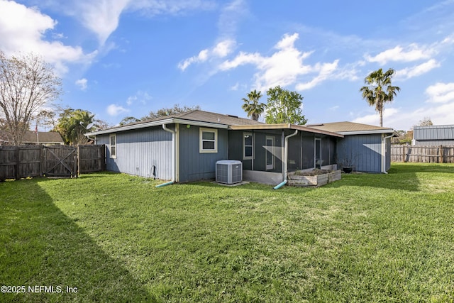 rear view of house with cooling unit, a fenced backyard, a yard, and a sunroom