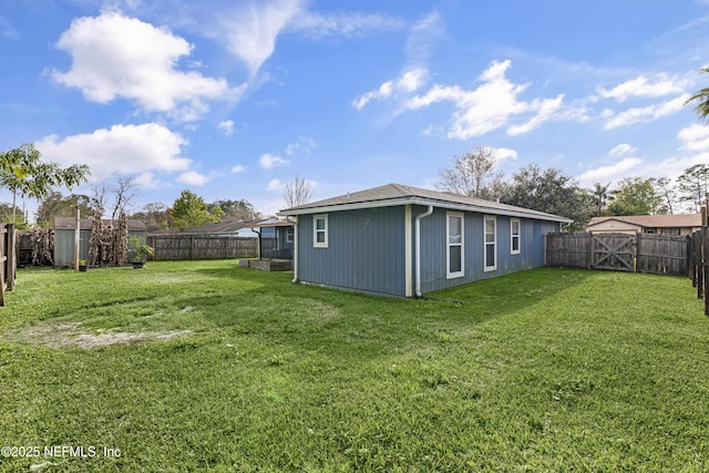 back of property featuring a lawn, a fenced backyard, and a gate