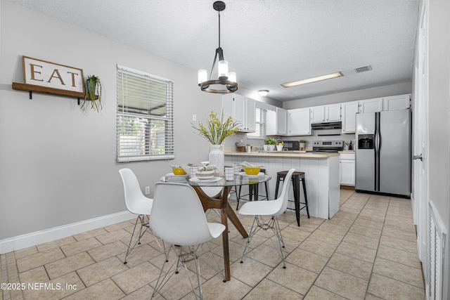 dining space featuring visible vents, baseboards, light tile patterned floors, a notable chandelier, and a textured ceiling