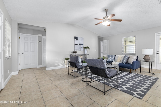 dining space featuring a textured ceiling, lofted ceiling, light tile patterned flooring, and ceiling fan