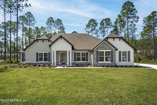 view of front of house featuring stone siding, a shingled roof, a front lawn, and board and batten siding