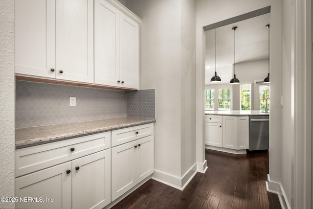 kitchen with baseboards, dark wood finished floors, dishwasher, white cabinetry, and backsplash