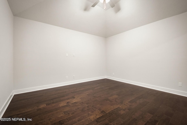 empty room with ceiling fan, dark wood-style flooring, vaulted ceiling, and baseboards