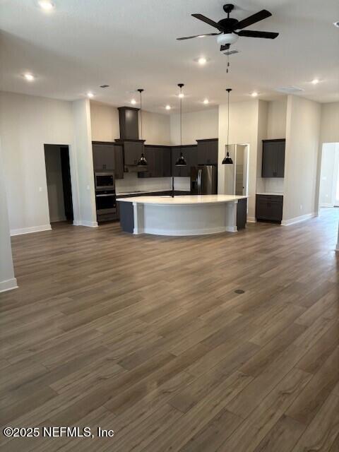 kitchen with recessed lighting, open floor plan, a large island, and stainless steel appliances