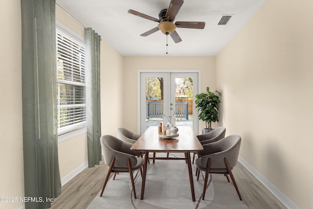 dining space with a ceiling fan, baseboards, visible vents, light wood-style floors, and french doors