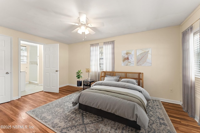 bedroom with multiple windows, wood finished floors, and baseboards