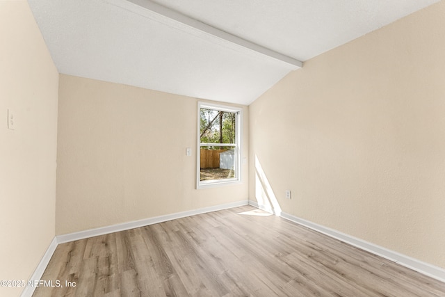 unfurnished room with vaulted ceiling with beams, wood finished floors, and baseboards