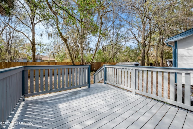 wooden terrace with a fenced backyard