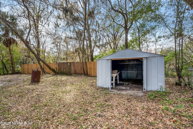 view of yard featuring a storage shed, fence, and an outdoor structure