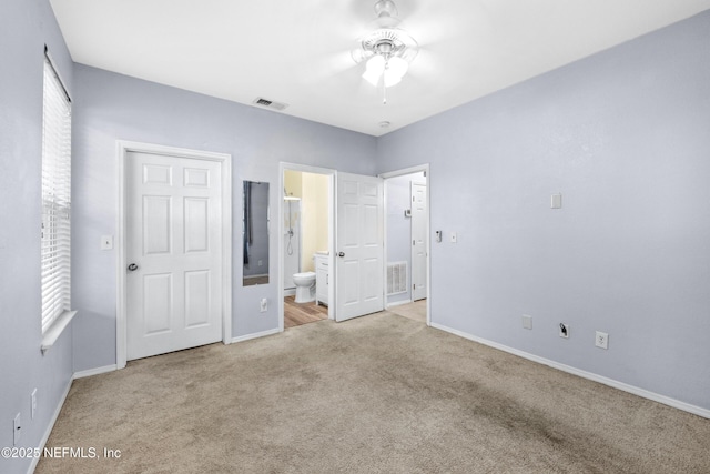unfurnished bedroom featuring multiple windows, visible vents, and light carpet