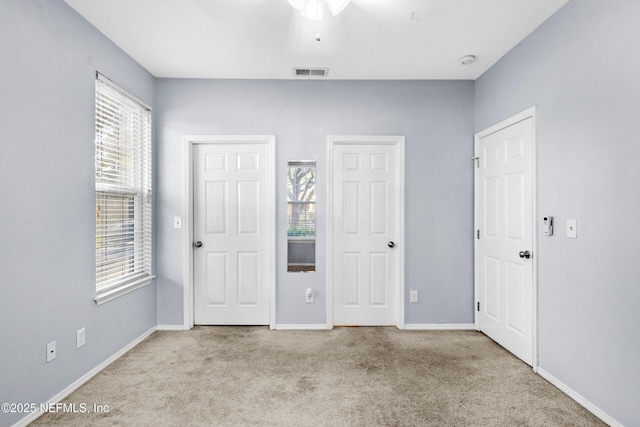 unfurnished bedroom with visible vents, baseboards, and carpet flooring