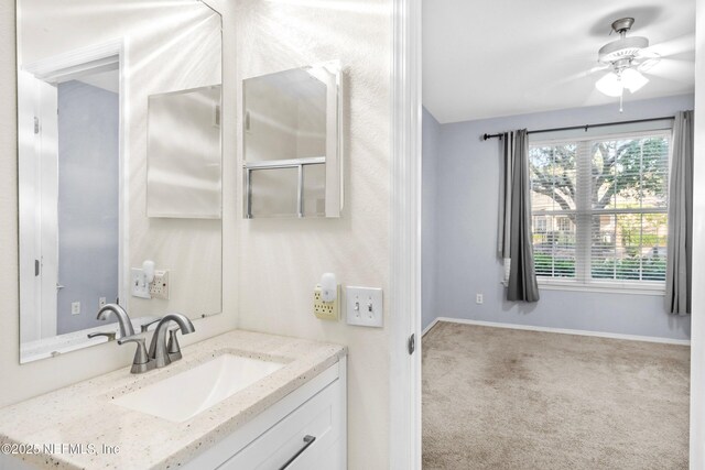 bathroom featuring ceiling fan, vanity, and baseboards