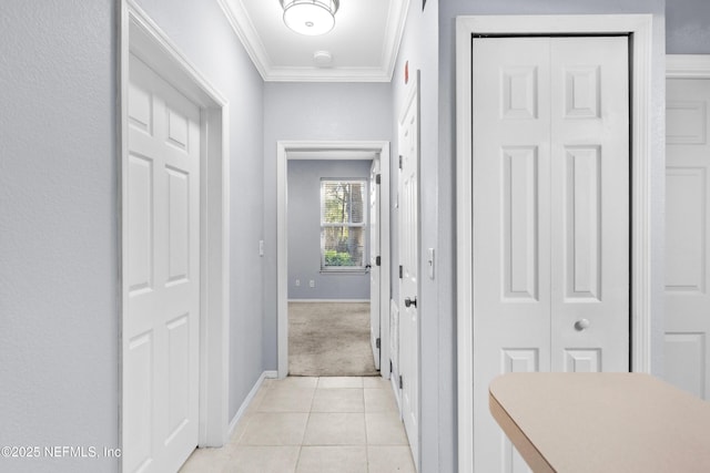 corridor with light tile patterned floors, baseboards, and ornamental molding