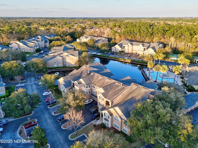 drone / aerial view featuring a residential view and a wooded view