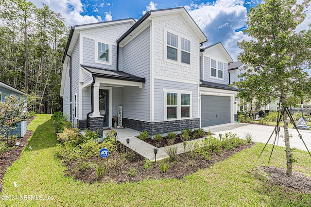 view of front of house with stone siding, driveway, a front lawn, and a garage