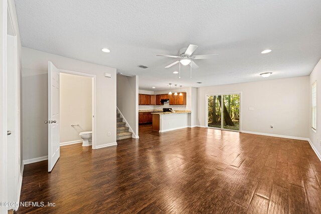 unfurnished living room featuring recessed lighting, dark wood-style floors, and baseboards