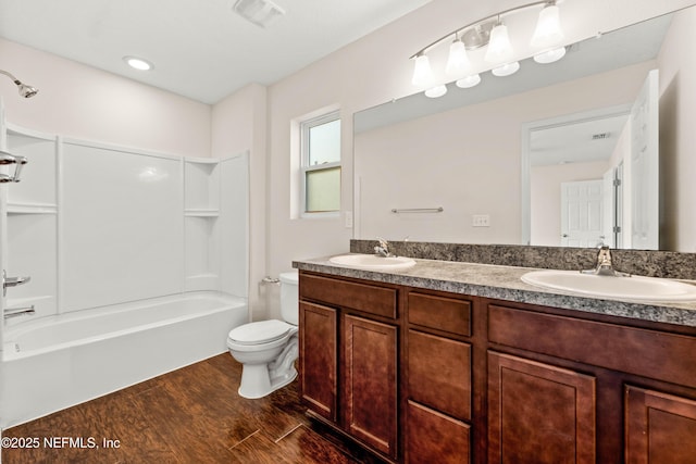 bathroom with a sink, visible vents, toilet, and wood finished floors