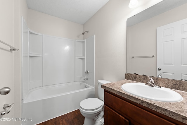 bathroom with toilet, a textured ceiling, wood finished floors, tub / shower combination, and vanity