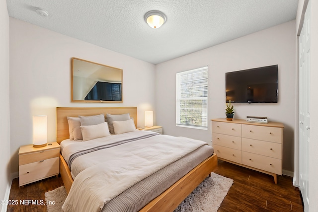 bedroom with dark wood finished floors and a textured ceiling