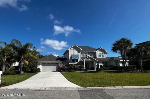 view of front of home featuring a front yard, an attached garage, and driveway