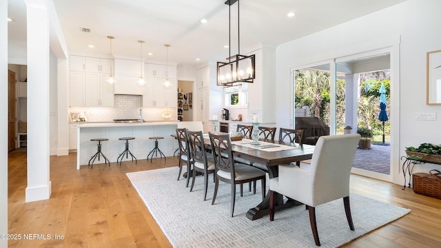 dining area with a notable chandelier, recessed lighting, visible vents, and light wood-type flooring