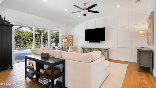 living room with visible vents, light wood-style flooring, recessed lighting, a decorative wall, and ceiling fan