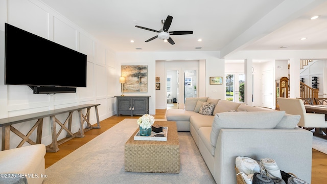 living area with ceiling fan, stairs, recessed lighting, light wood-style floors, and a decorative wall