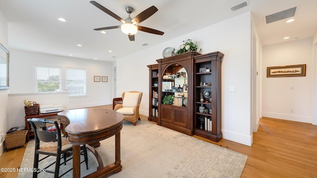 office featuring a ceiling fan, visible vents, baseboards, recessed lighting, and light wood-style floors