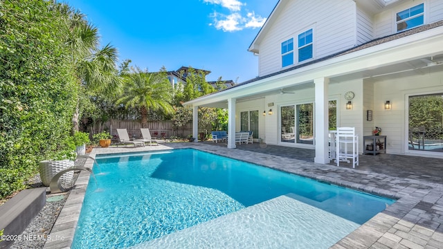 view of swimming pool featuring a fenced in pool, a patio, ceiling fan, and fence