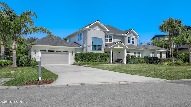 view of front facade featuring board and batten siding, a front lawn, an attached garage, and concrete driveway