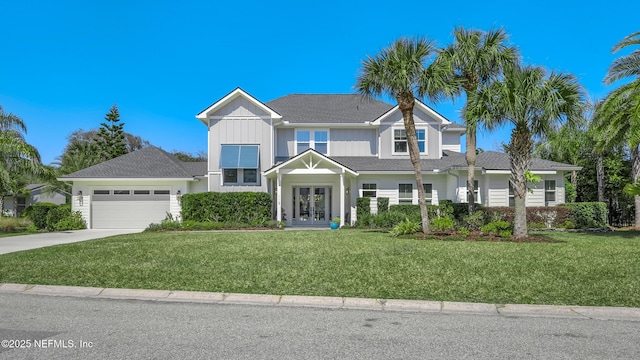 view of front of house with french doors, a front yard, driveway, and a garage