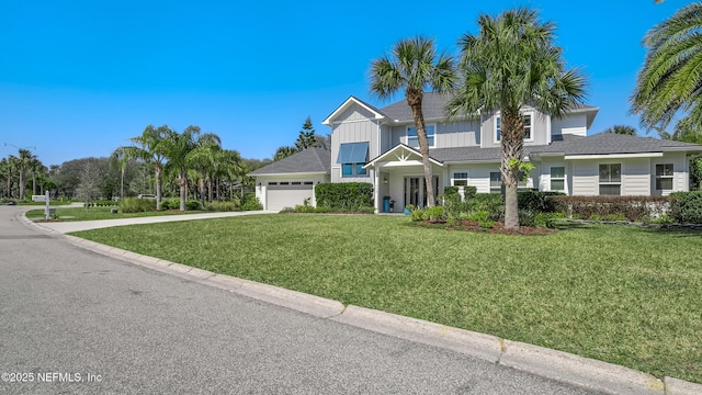 view of front of property featuring board and batten siding, concrete driveway, a garage, and a front lawn