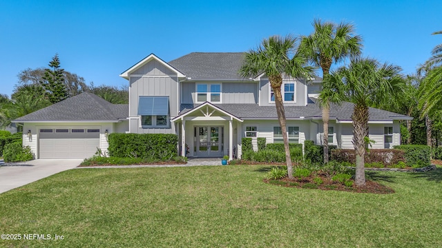 view of front of home featuring french doors, an attached garage, a front yard, and concrete driveway