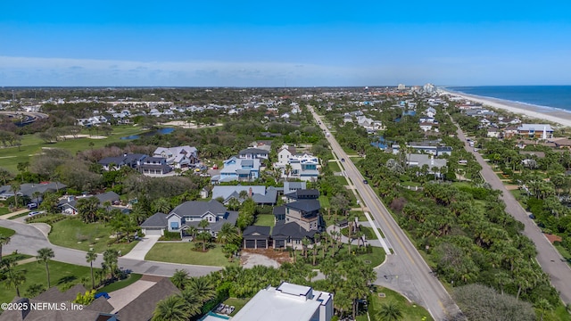 aerial view featuring a view of the beach, a water view, and a residential view