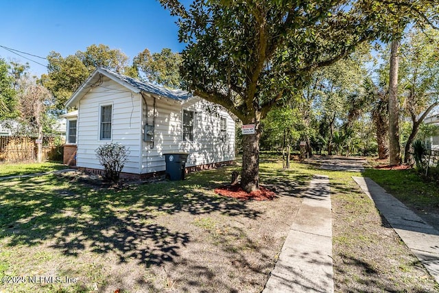 view of home's exterior featuring a yard and fence