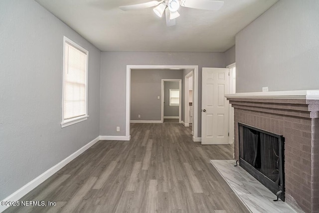 8027 Floyd St, Jacksonville, FL 32208 - unfurnished living room featuring ceiling fan, a fireplace, baseboards, and wood finished floors