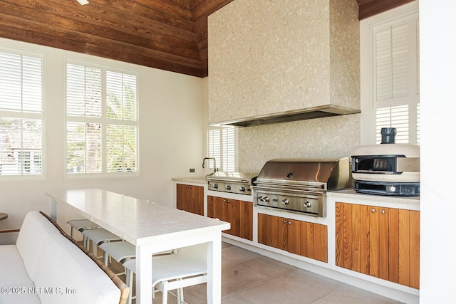 kitchen featuring brown cabinetry, light tile patterned floors, light countertops, and tasteful backsplash