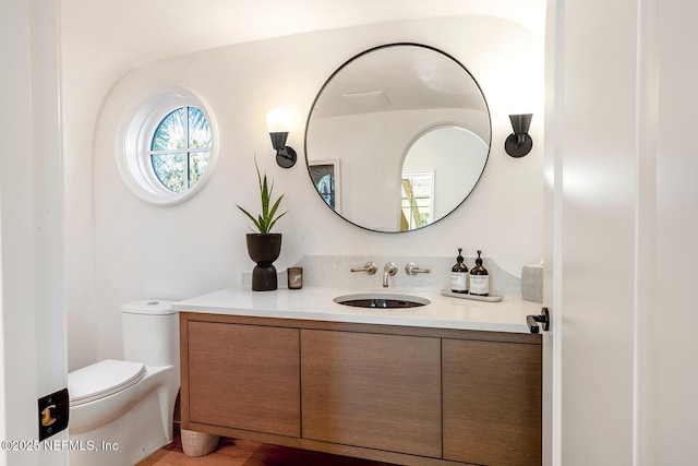 half bath featuring toilet and vanity