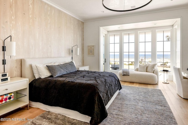 bedroom featuring multiple windows, wood finished floors, and crown molding