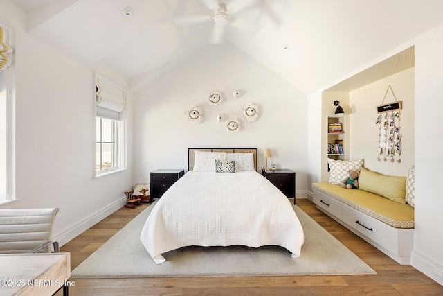 bedroom featuring a ceiling fan, vaulted ceiling, light wood-style flooring, and baseboards