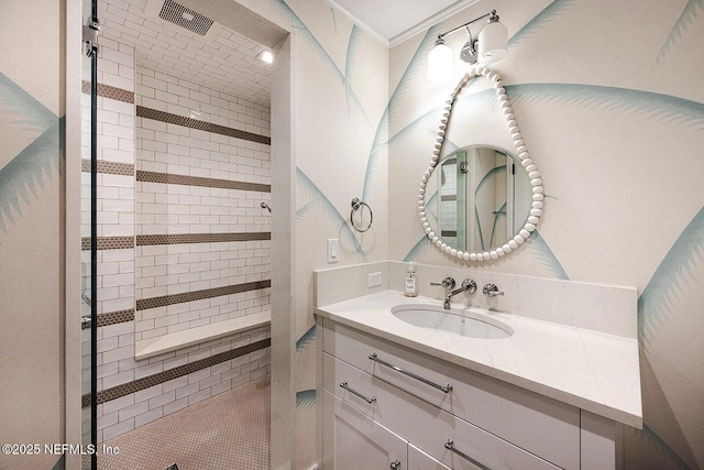 full bathroom featuring visible vents, tiled shower, and vanity